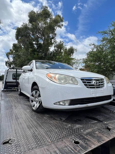 Sedán Hyundai sobre una grúa de plataforma en Dania Beach.