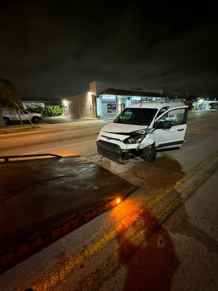 A night pickup by a flatbed tow truck in Tamarac, Florida.