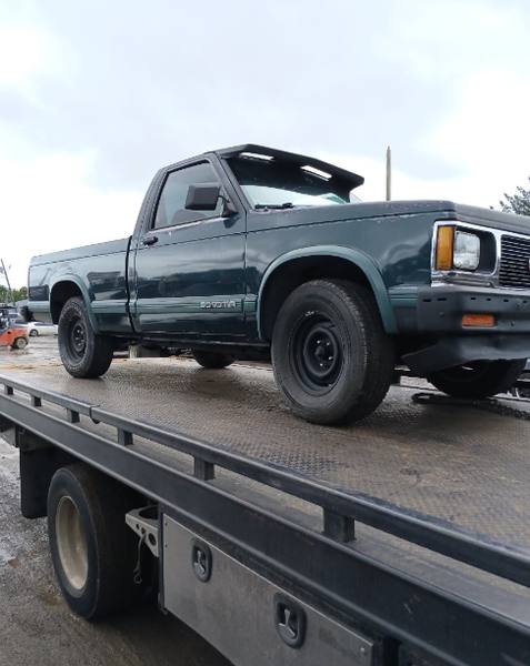 Grúa de plataforma transportando una camioneta en Plantation.