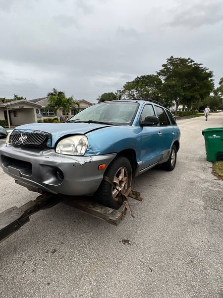 SUV asegurada sobre una grúa de plataforma en Pompano Beach.