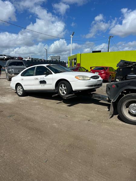 A wheel-lift tow truck picking up a sedan in Deerfield Beach.
