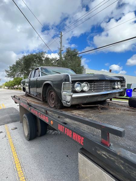 A vintage Lincoln on a rollback tow truck in Lauderhill.