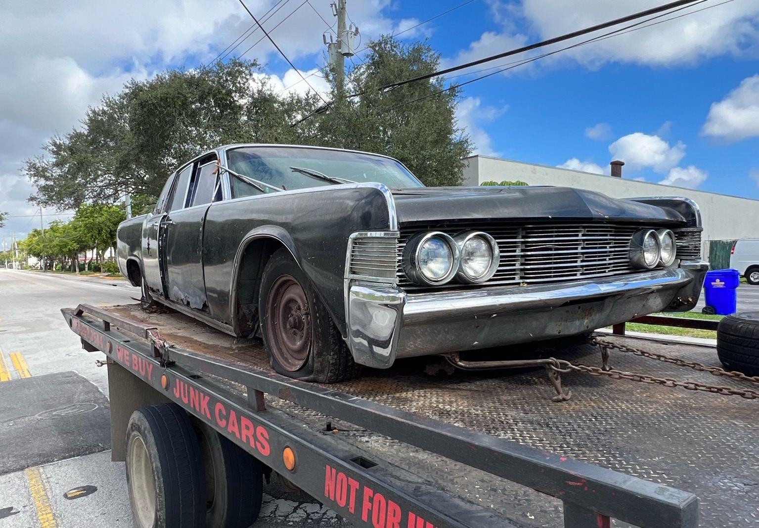 An old car at the end of the road, ready for pickup.