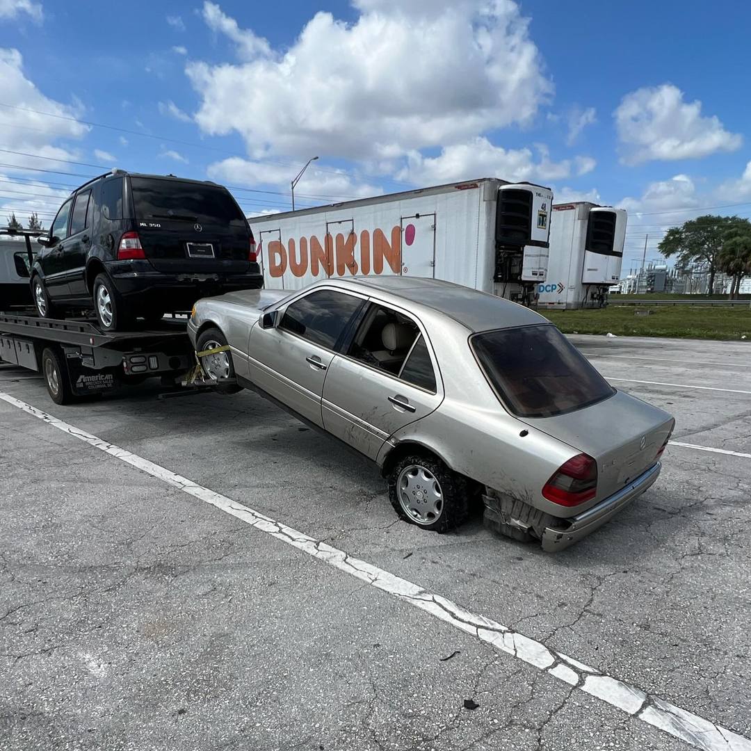 Two junk cars picked up together on a tow truck in South Florida.
